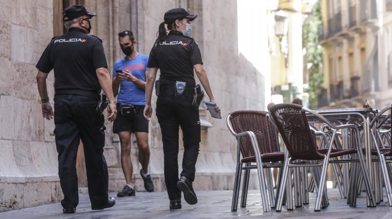 Dos policías nacional patrullan por Valencia durante la pandemia del coronavirus