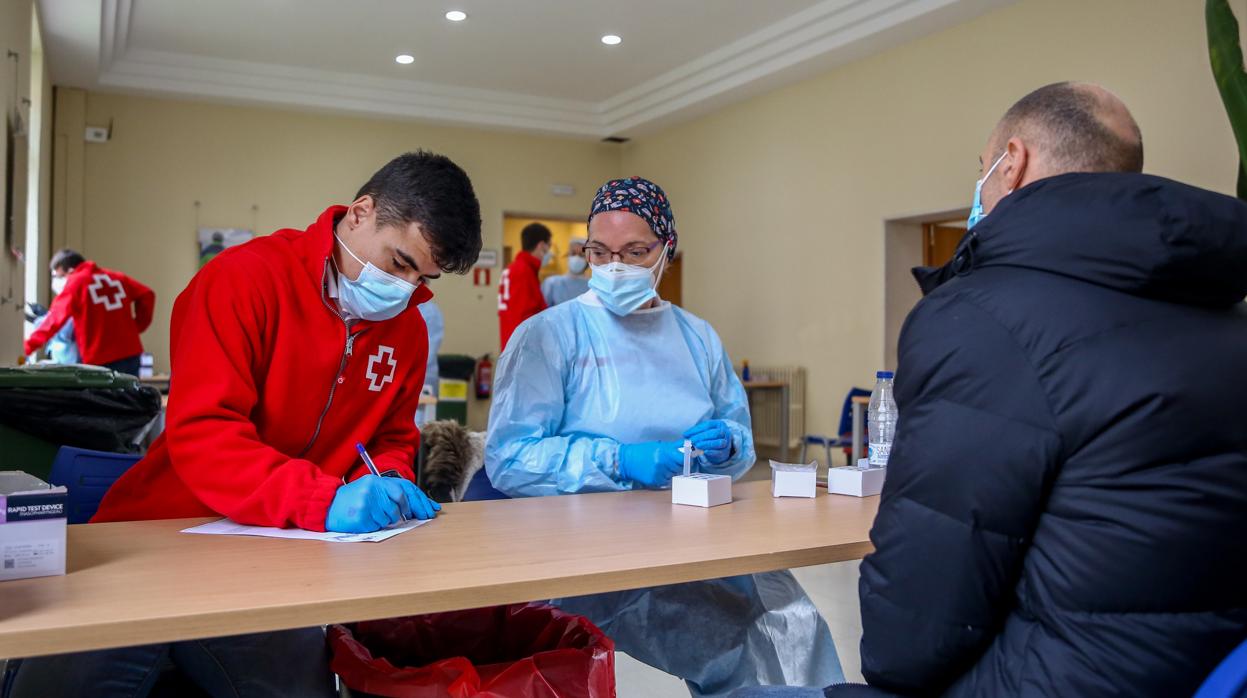 Un voluntario de Cruz Roja toma los datos a un hombre, durante uno de los dispositivos del test de antígenos en Madrid