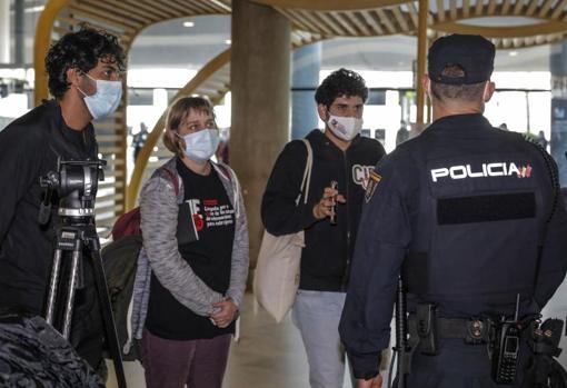 Imagen de los miembros de «CIEs NO» hablando con un agente de la Policía Nacional