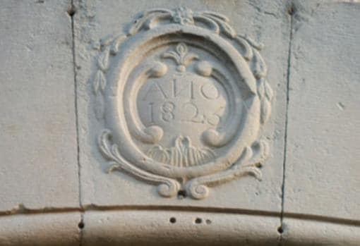 Detalle de la inscripción que adorna la puerta de acceso al edificio, relativo a una reforma realizada en 1825 en esta antigua fábrica de papel