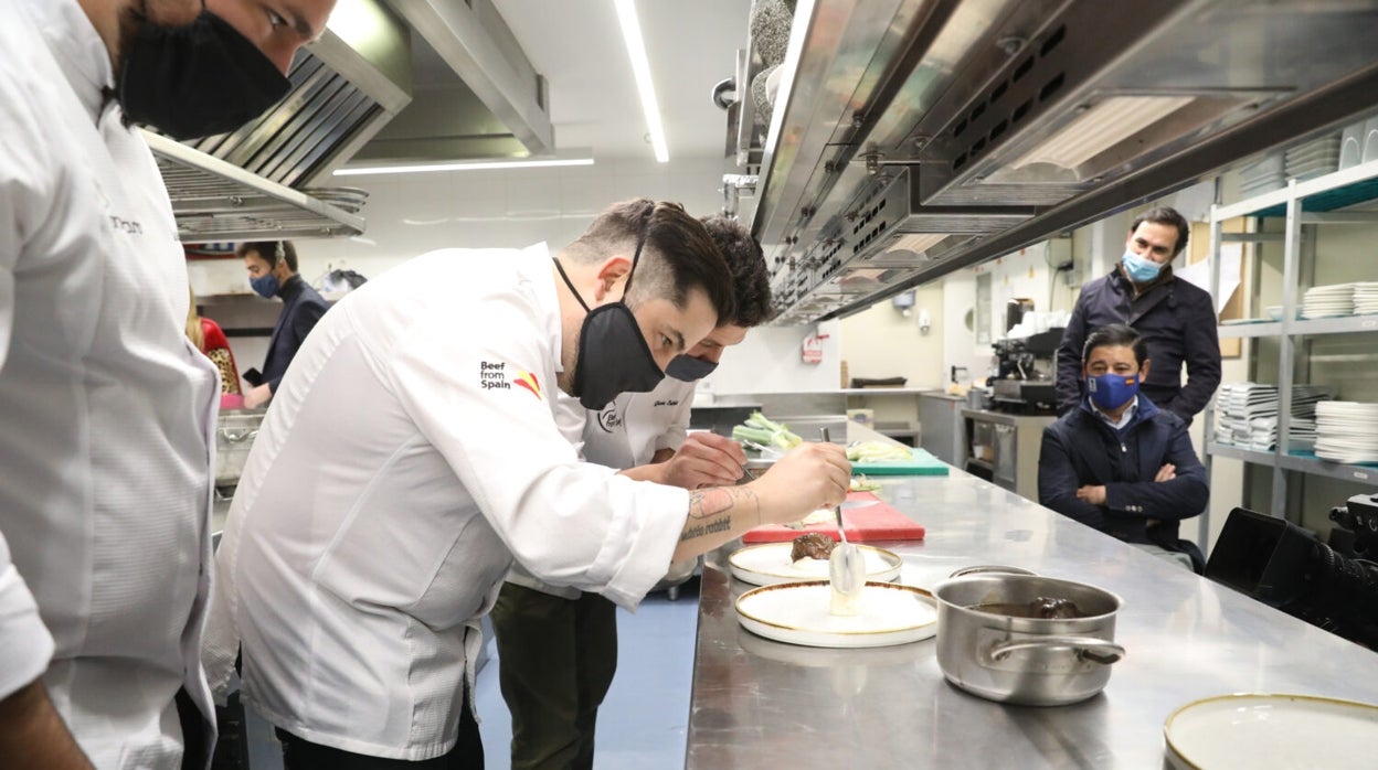 Varios chefs participantes, cocinan los platos, bajo la mirada del concejal del distrito de Vallecas, Borja Fanjul