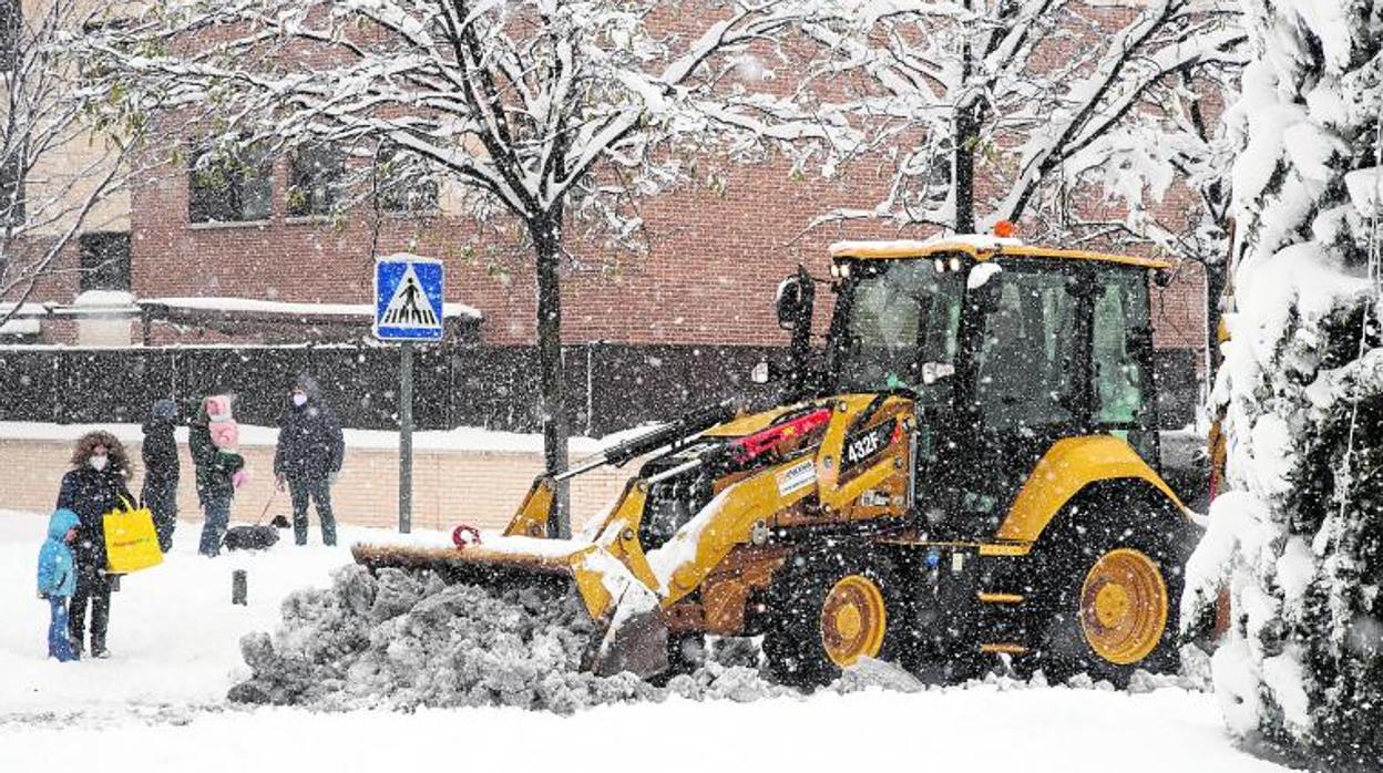 Una máquina quitanieves trata de limpiar la calzada de nieve en Torrejón