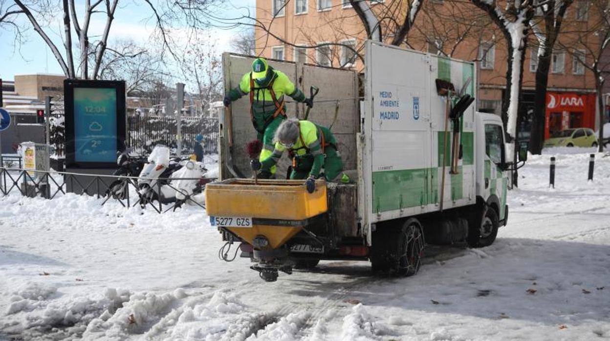 Operarios municipales repartiendo sal por las calles nevadas