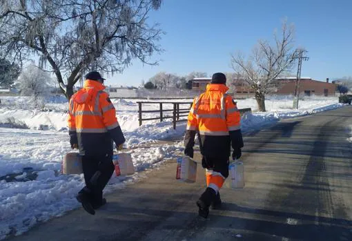 Dos voluntarios llevan pañales a personas dependientes