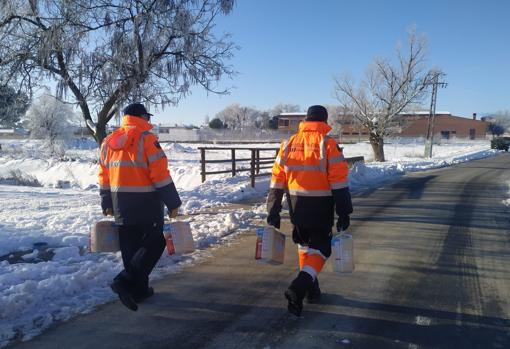 Dos voluntarios llevan pañales a personas dependientes