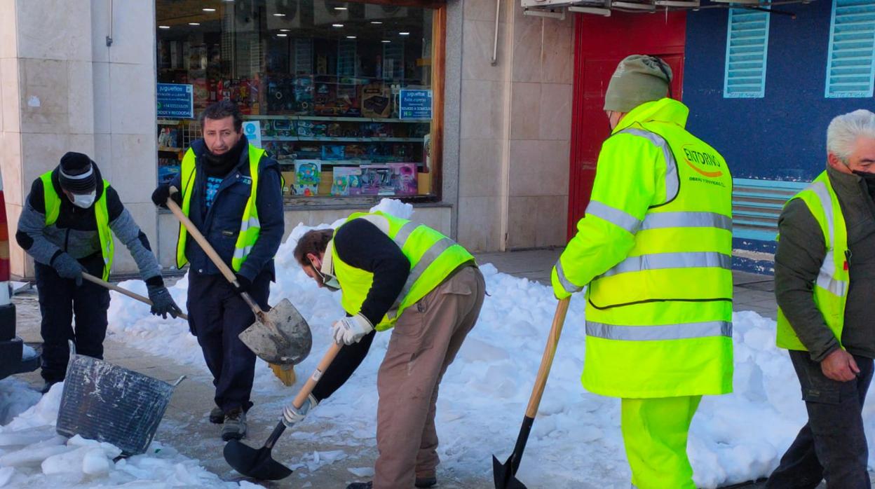 Trabajadores retirando nieve en una calle de Toledo