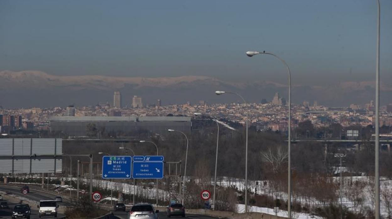 Los avisos en las carreteras que advierten que hay que circular a 70 k/h y la boina de contaminación sobre la ciudad