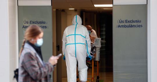 Imagen de un sanitario trasladando a un enfermo en el Hospital Clínico de Valencia