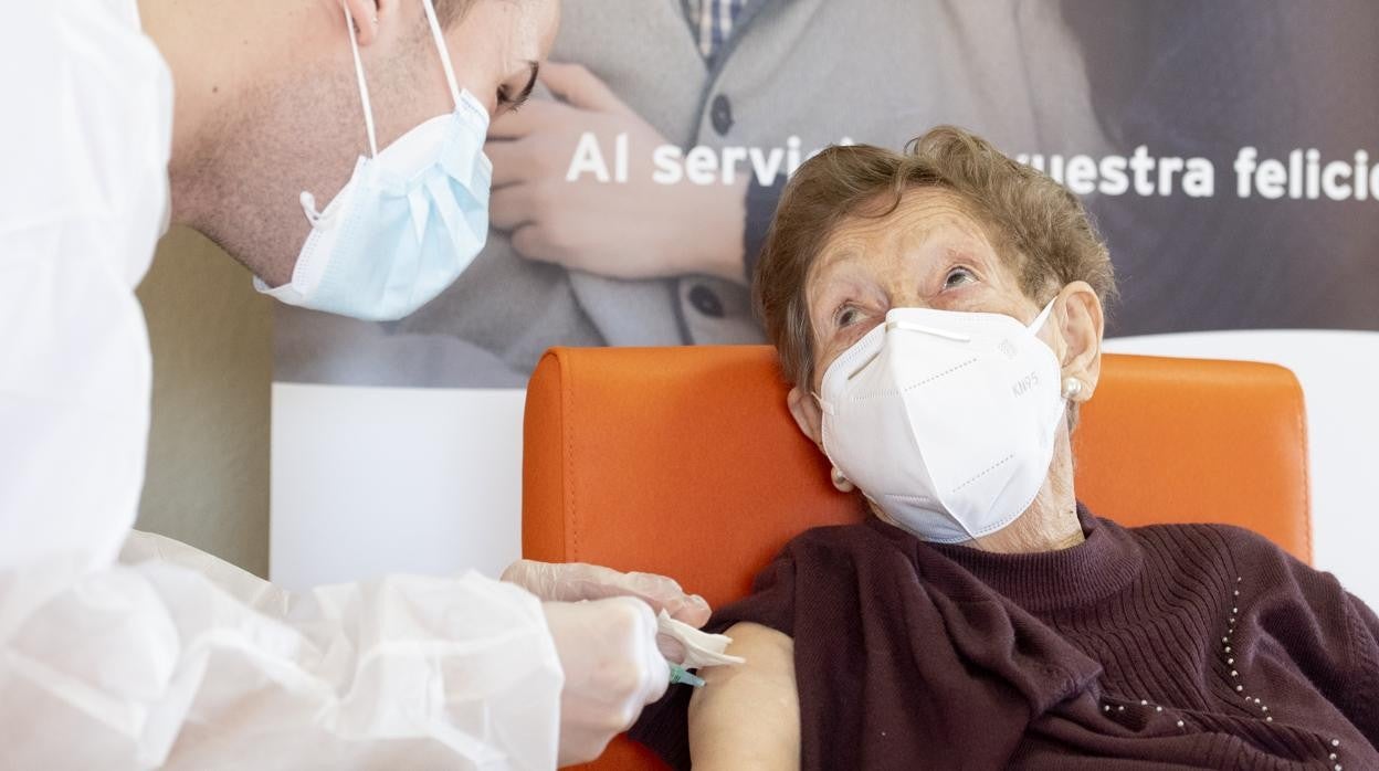 Un sanitario vacuna a una de las residentes de un centro en Alcalá de Henares