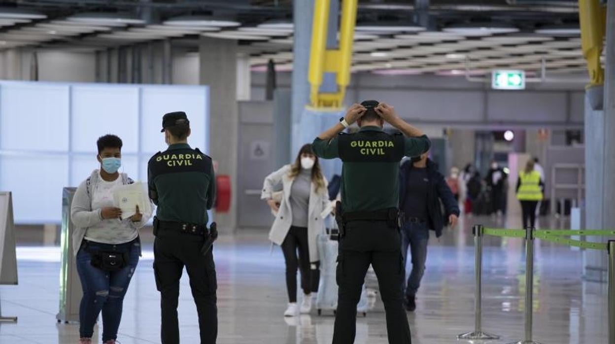 Dos agentes de la Guardia Civil en un control de pasajeros en el aeropuerto de Barajas