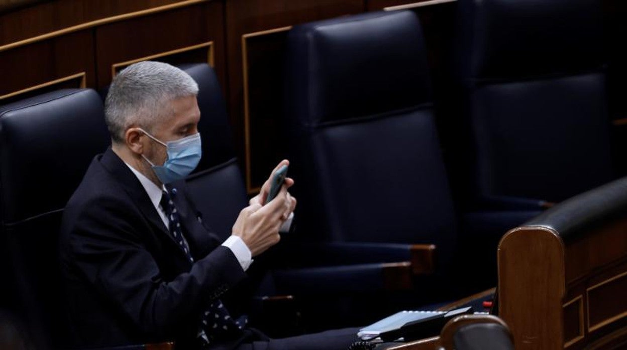 El ministro del Interior consulta su teléfono móvil en el Congreso