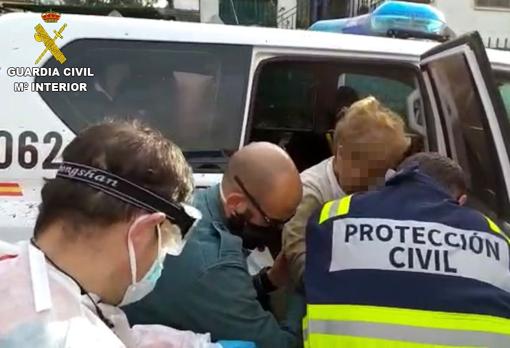 Elisa es ayudada por un guardia civil y un voluntario de Protección Civil tras ser localizada