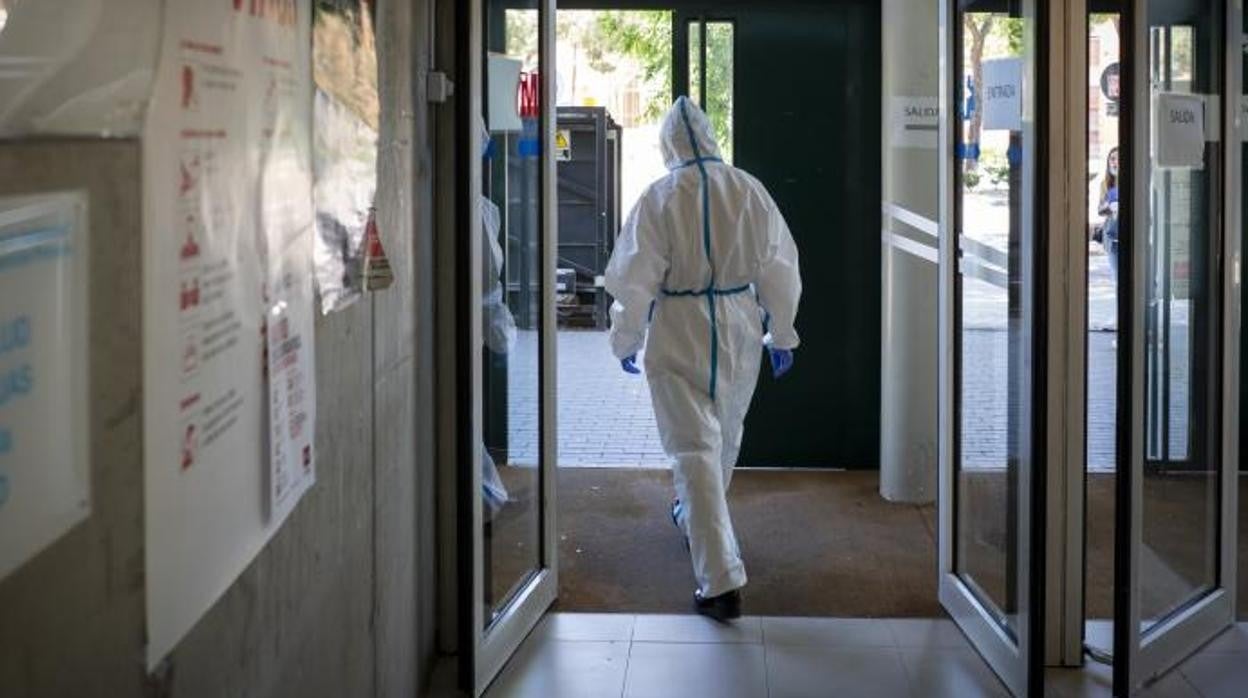 Un sanitario equipado con un Epi sale de un centro de salud para ir a una visita domiciliaria