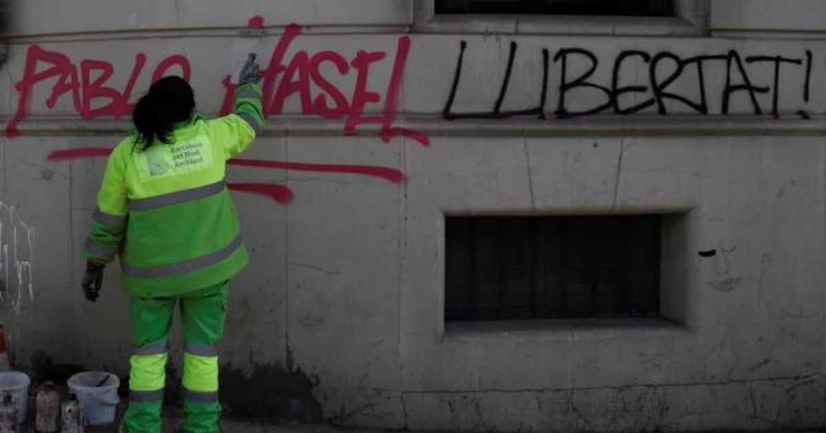 perarios de limpieza borran una pintada en el centro de Barcelona