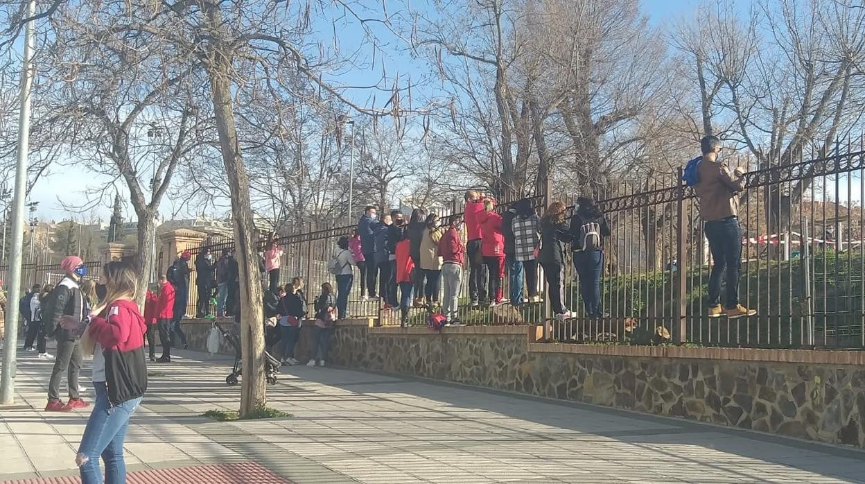 Familiares subidos a la verja de la instalación deportiva esta mañana