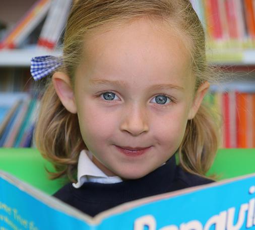 Alumna de Infantil de Caxton College leyendo en la biblioteca de este centro británico