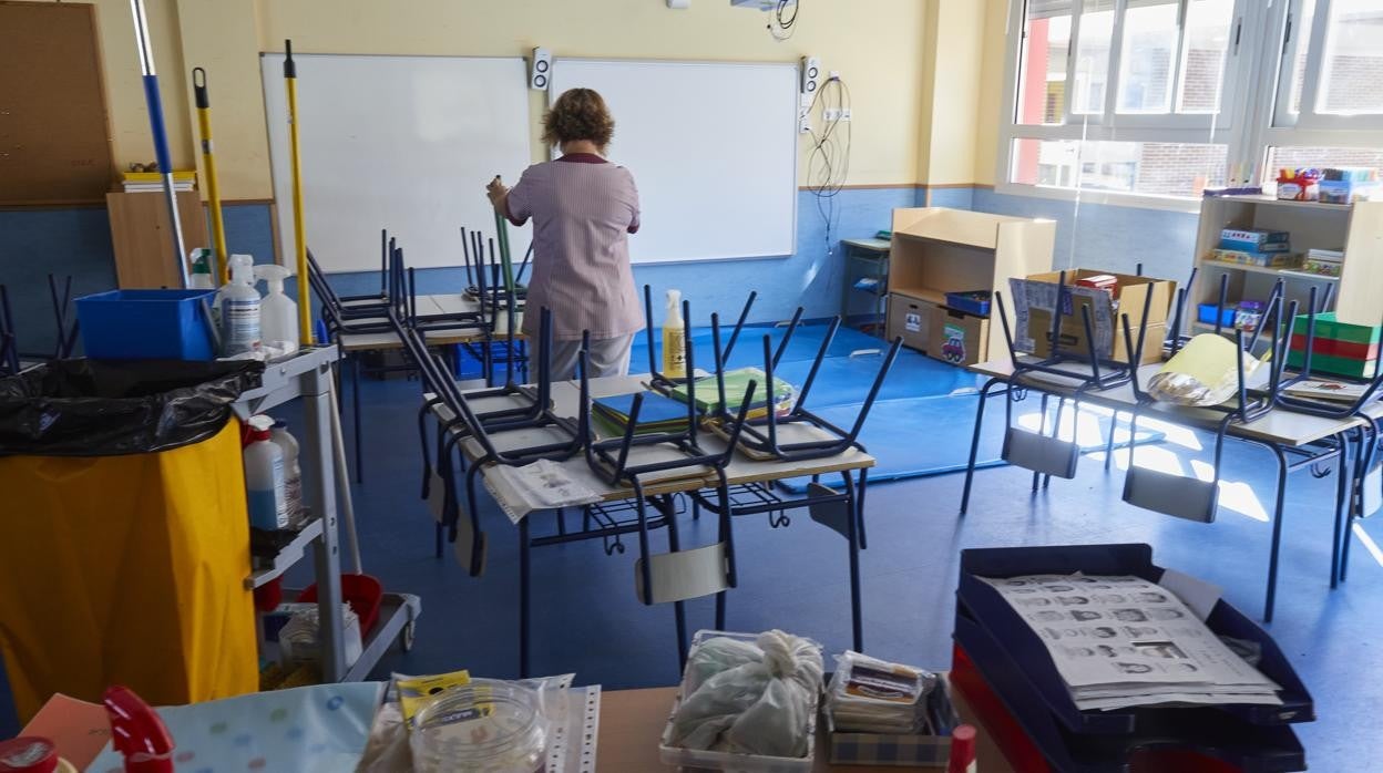 Una limpiadora prepara una clase de un colegio en Arganda para la vuelta de los alumnos el pasado mes de septiembre