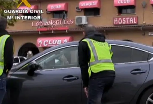 Dos agentes, parapetados tras un coche delante del club Los Ángeles