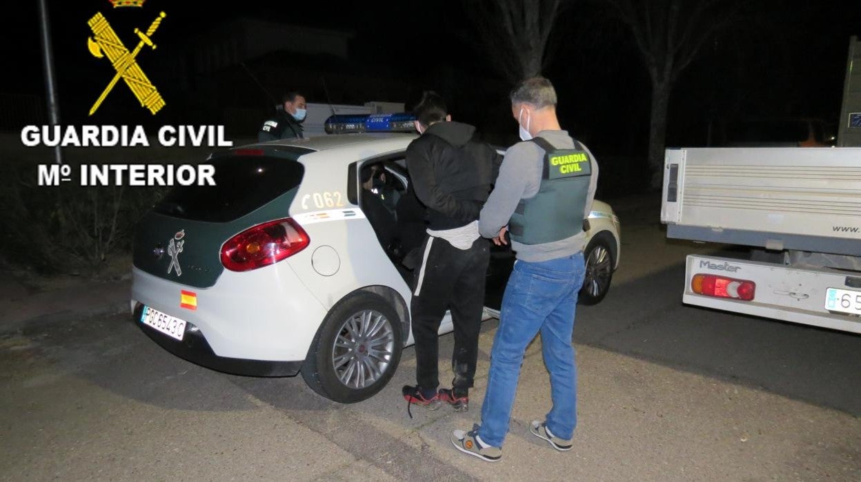 Agentes de la Guardia Civil conducen hasta un vehículo de patrulla a uno de los detenidos