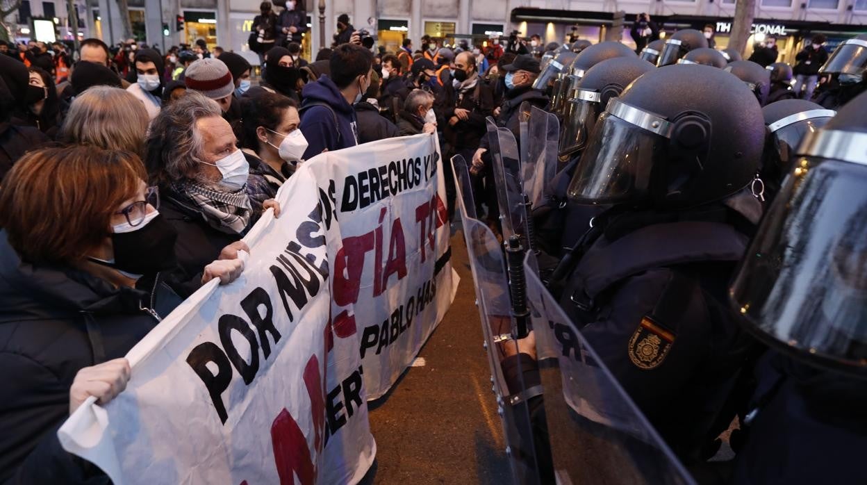 Manifestantes sostienen la pancarta frente a la Policía