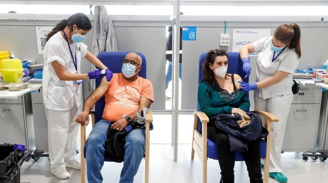 Dos personas, recibiendo su vacuna en el espacio habilitado para ello en el Hospital Enfermera Isabel Zendal