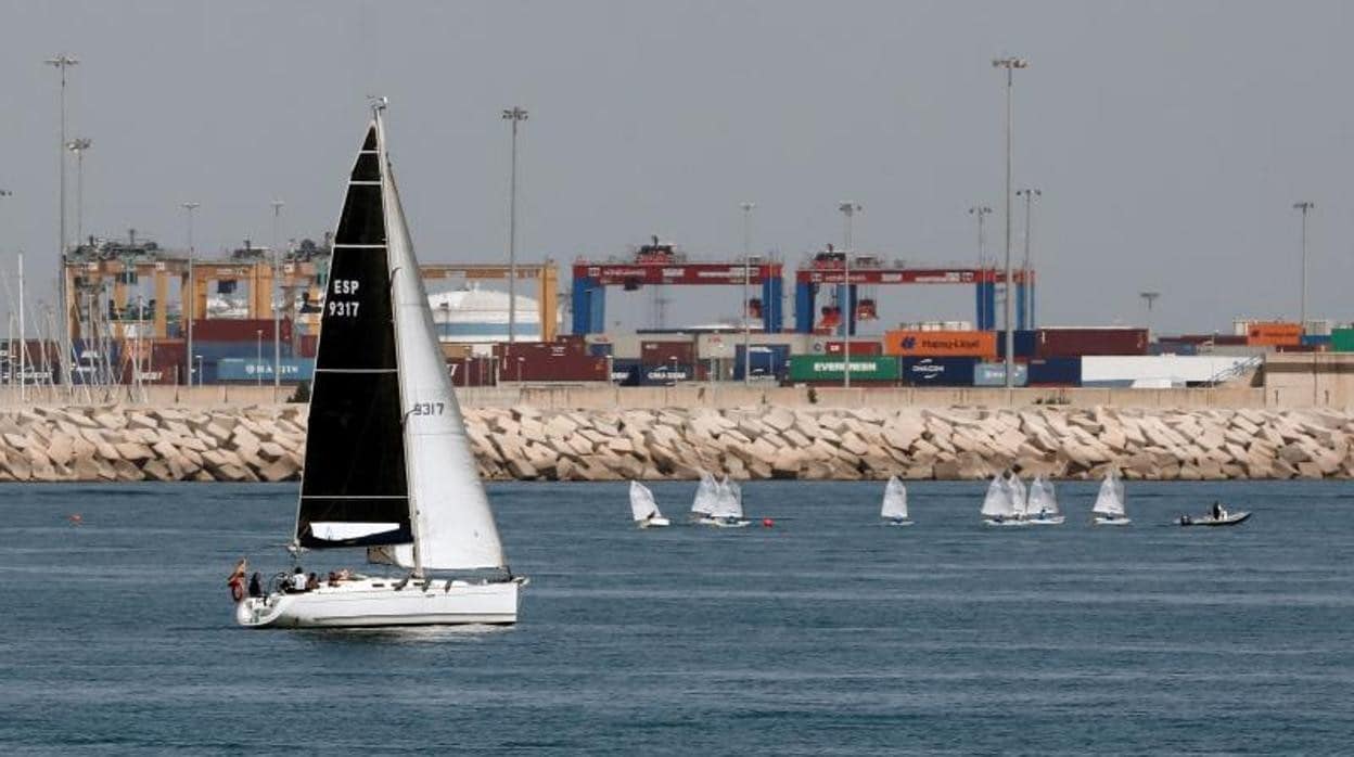 Un velero navega por la zona portuaria de Valencia, este Sábado Santo