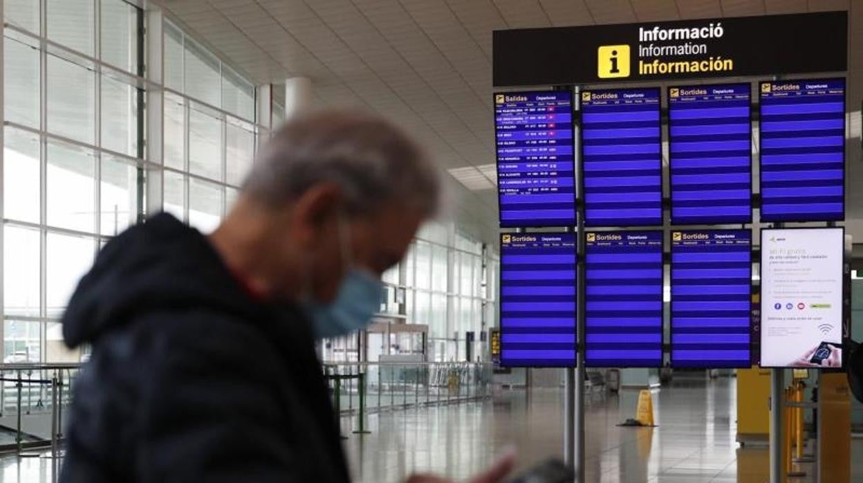 Un pasajero ante los paneles de información del Aeropuerto de Barcelona-El Prat