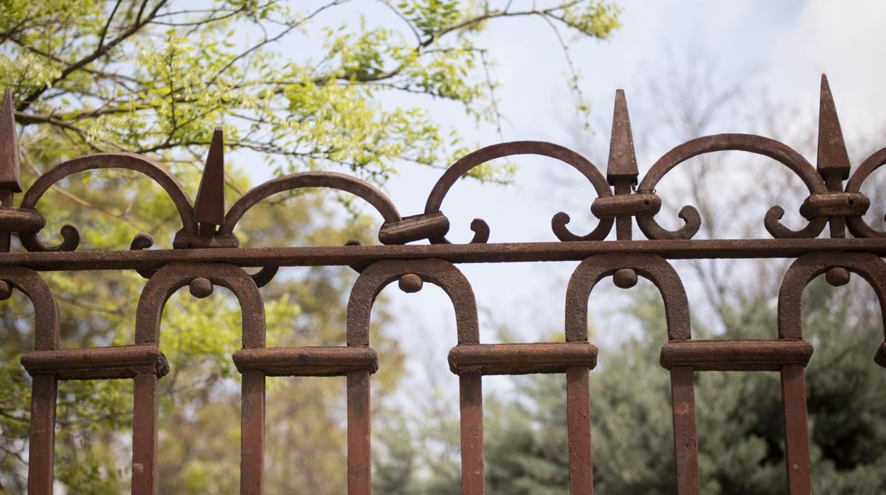 La verja de hierro forjado, oxidada y dañada, del parque Casino de la Reina