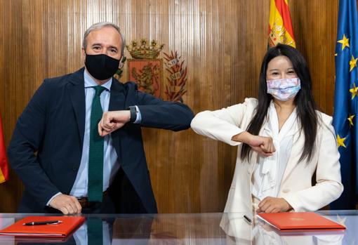 El alcalde de Zaragoza, Jorge Azcón, y la responsable de Ehang en España, Victoria Jing Xiang Ma, saludándose con los codos tras firmar el convenio