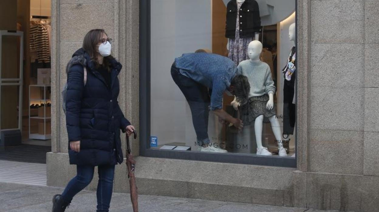 Comerciante prepara el escaparate de su tienda en Calle Príncipe, Vigo