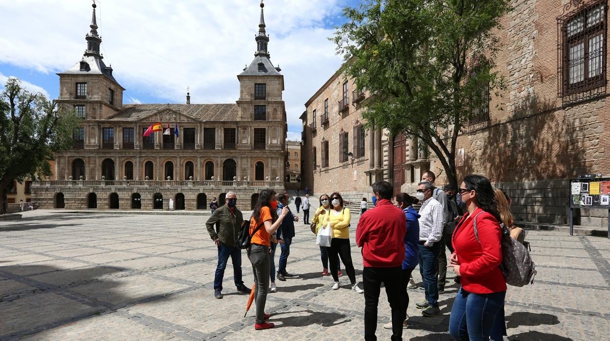 Un grupo de turistas, en una ruta guiada en plaza del Ayuntamiento de Toledo