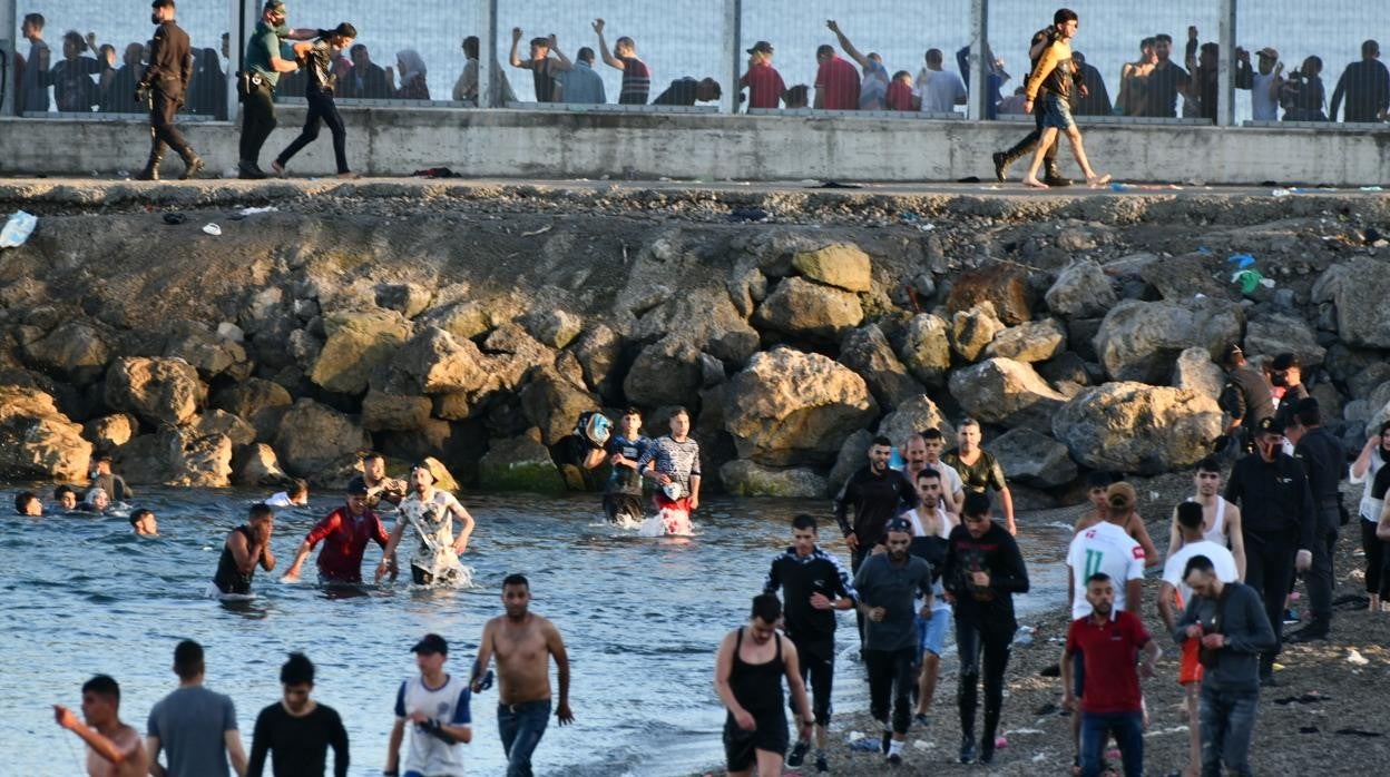 Espigón de Ceuta con cientos de inmigrantes llegando a nado