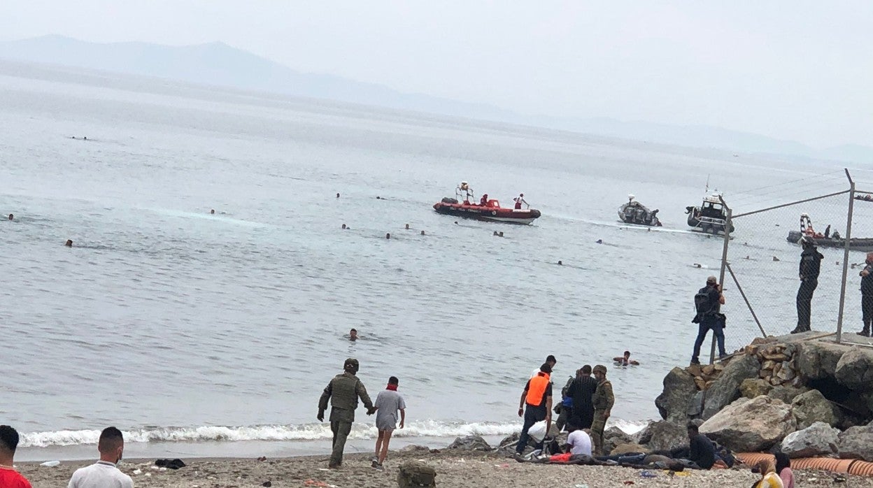 Un miembro de las Fuerzas y Cuerpos de Seguridad acompaña a un menor hacia el lado marroquí