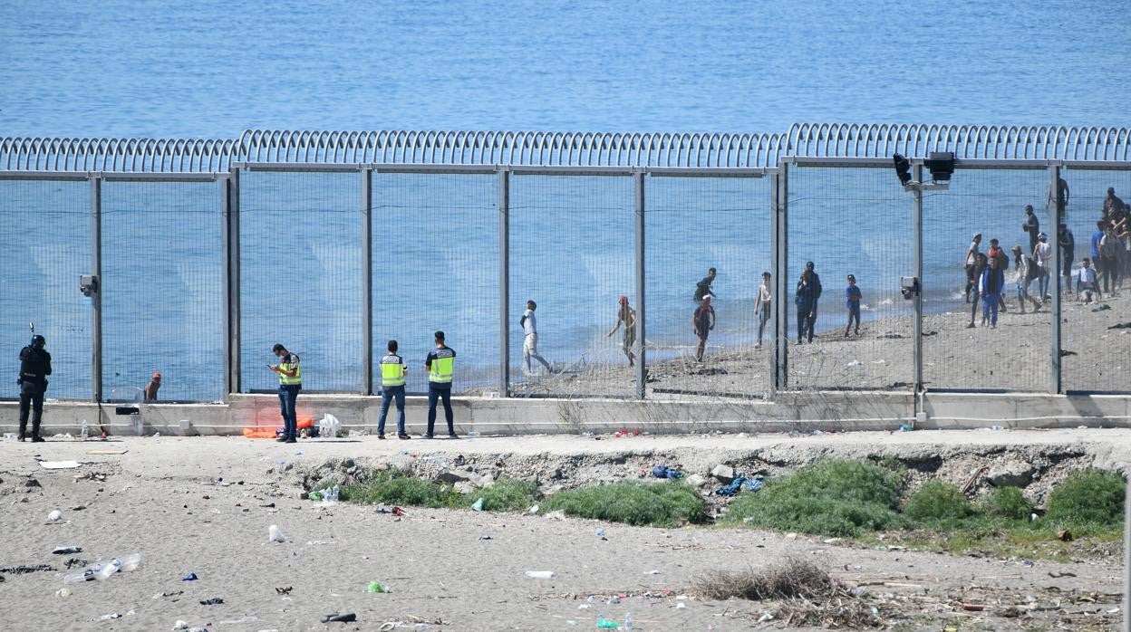 La valla que separa Ceuta de Marruecos con personas a la espera de cruzar