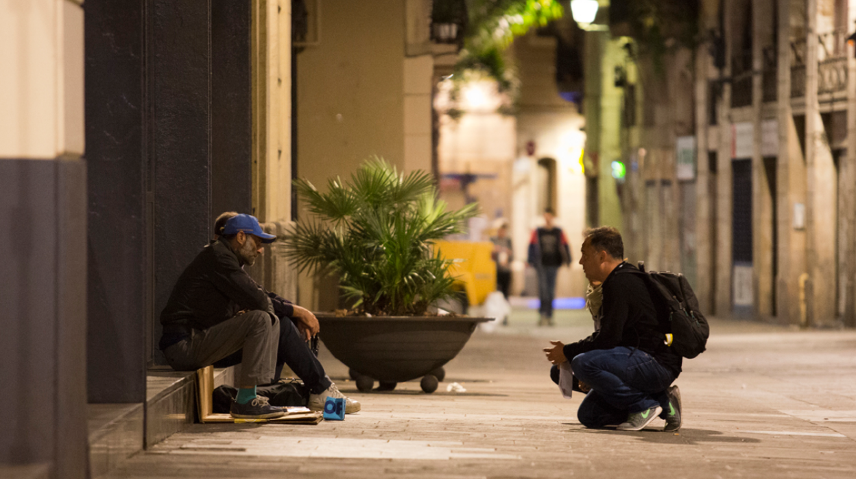 Dos personas sin techo hablando con dos trabajadores de Arrels