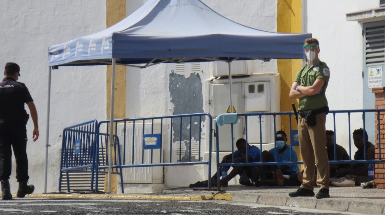 Foto de archivo: Un policía y un guarida de seguridad vigilan a un grupo de inmigrantes indocumentados que consiguieron saltar la valla en Melilla.