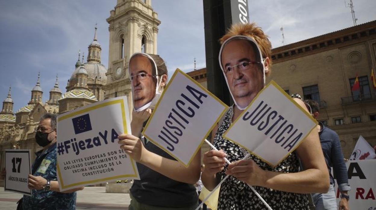 Manifestantes en la zaragozana Plaza del Pilar con caretas del ministro Iceta