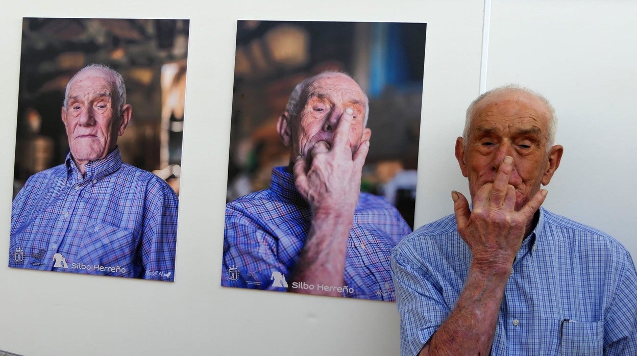 Uno de los protagonistas de la exposición posa junto a su fotografía