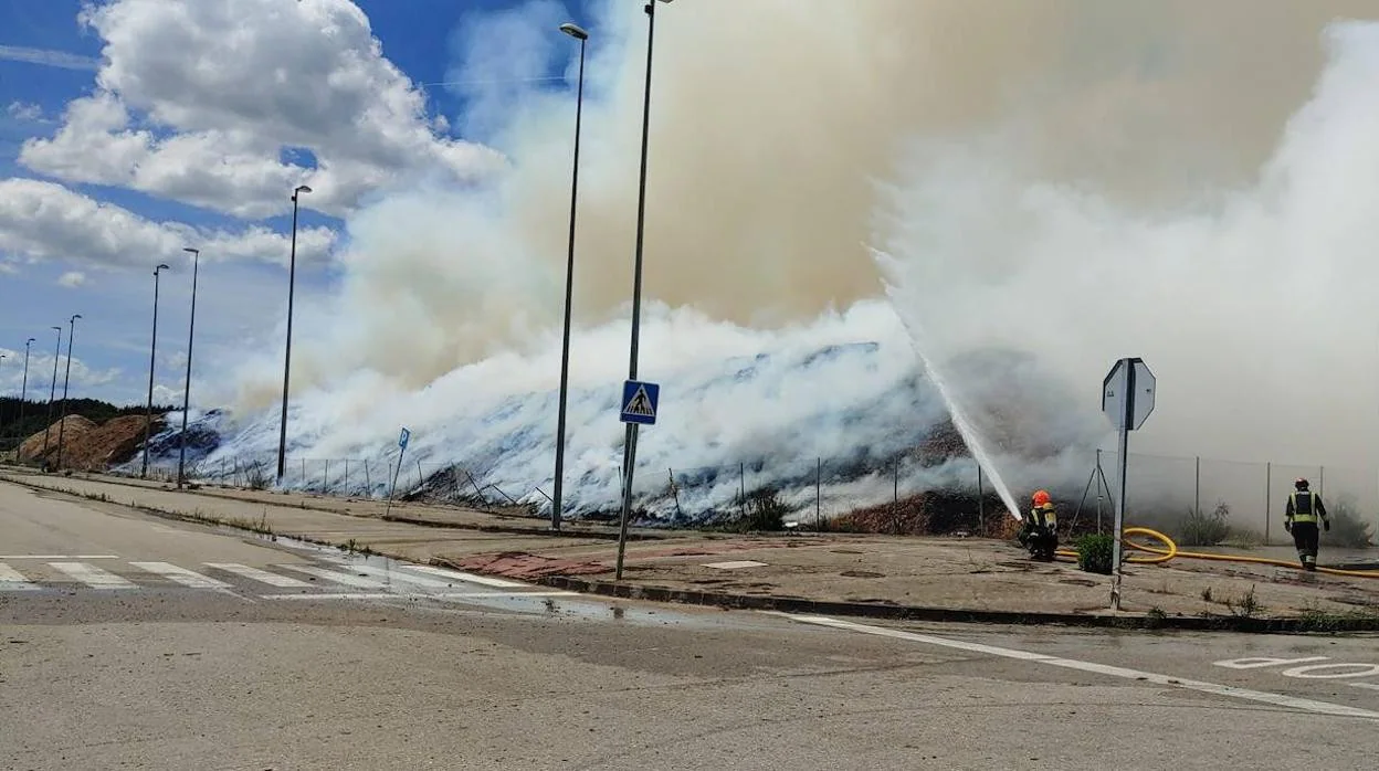 Efectivos de los Bomberos de Ponferrada, tratan de extinguir el incendio de una pila de biomasa en Cubillos del Sil.
