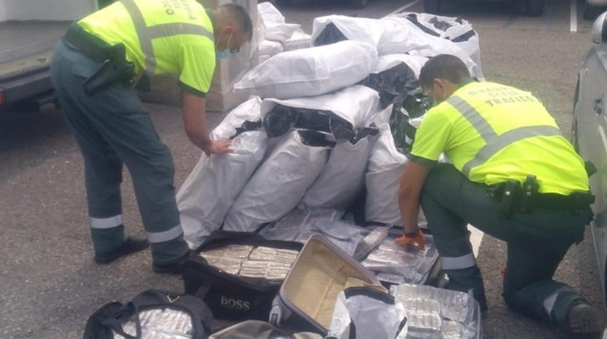 Agentes de la Guardia Civil, junto a los múltiples sacos y maletas con droga que llevaba la furgoneta