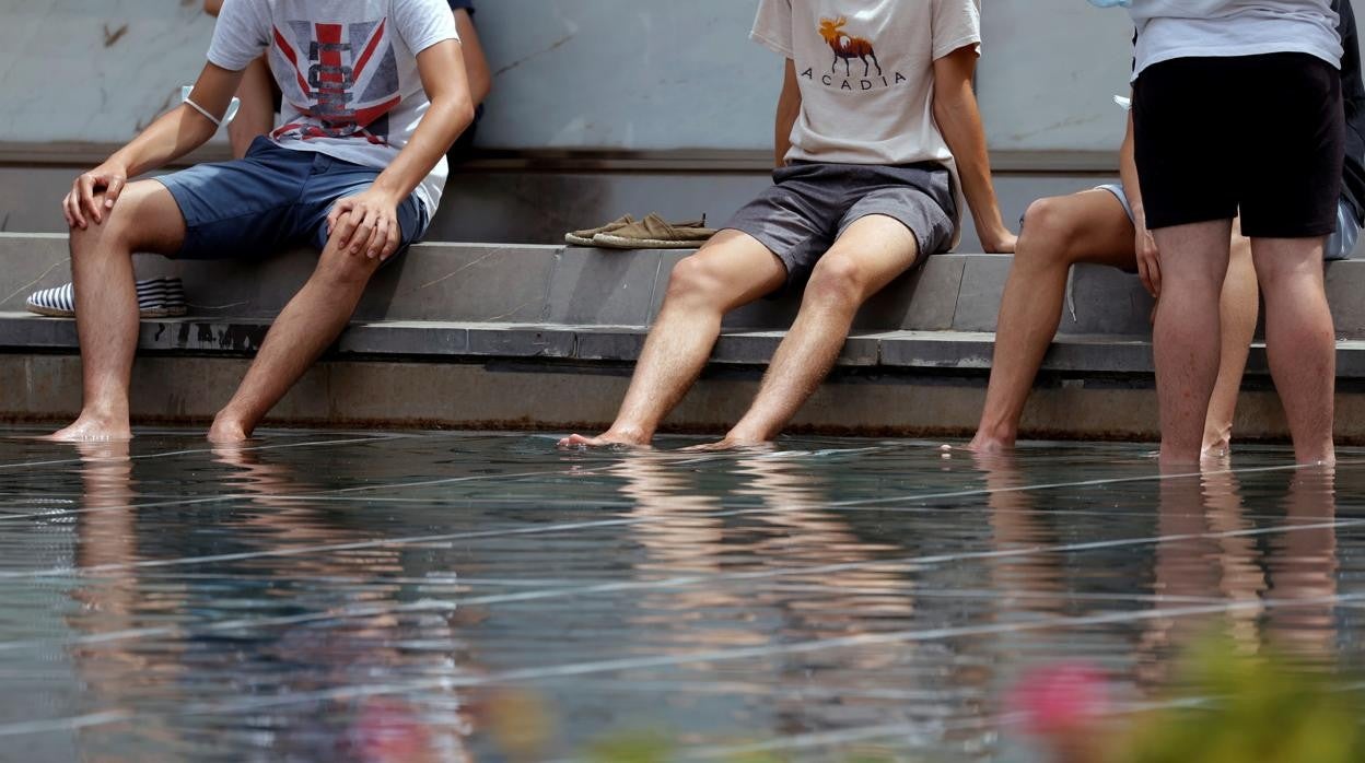 Imagen de personas sofocando el calor en una fuente en Valencia