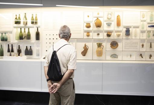 Un hombre observa los objetos hallados durante las excavaciones y expuestos en el nivel intermedio de la nueva estación, que acoge un pequeño museo arqueológico