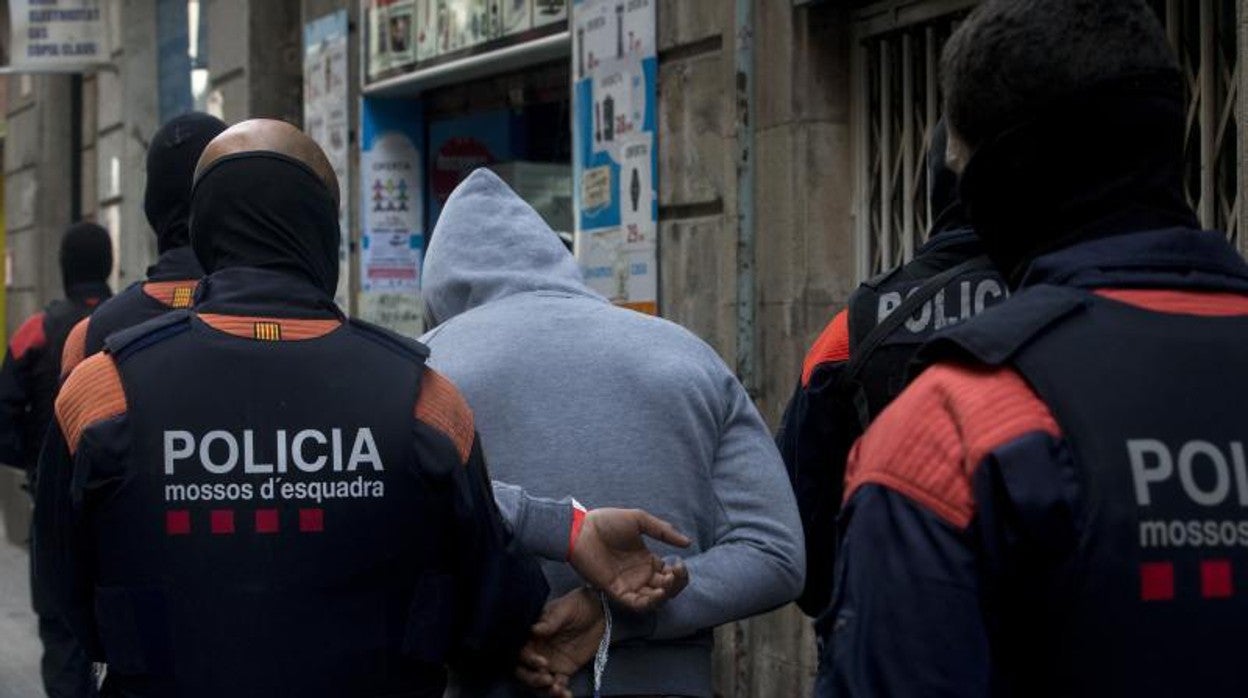 Mossos d'Esquadra custodian a un detenido en una operación contra el narcotráfico