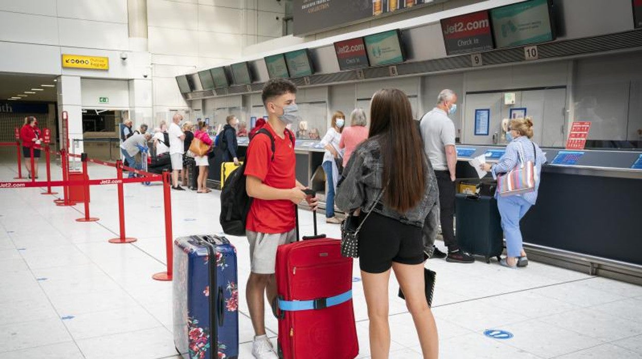 Pasajeros esperan por su check in en un aeropuerto de Canarias