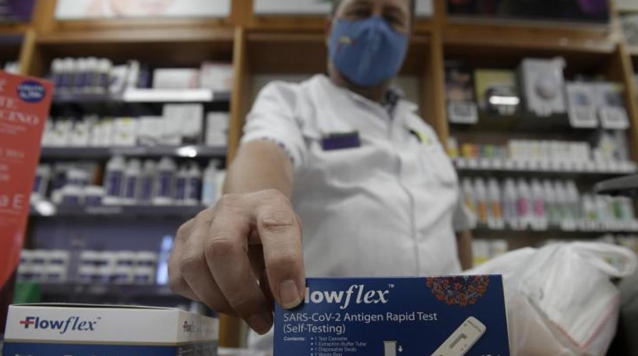 Un farmacéutico enseña un test de antígenos de detección del COVID-19 en Madrid