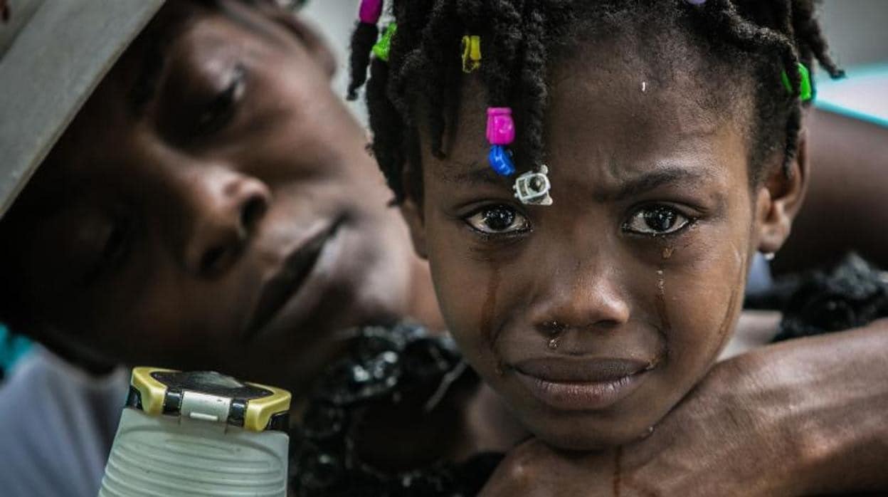 Una madre consuela a su hija en Haití tras el último terremoto