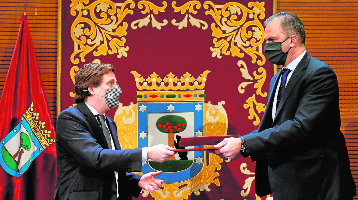 El alcalde de Madrid, José Luis Martínez-Almeida, intercambia unos documentos con el portavoz de Vox en el Ayuntamiento de la capital, Javier Ortega Smith