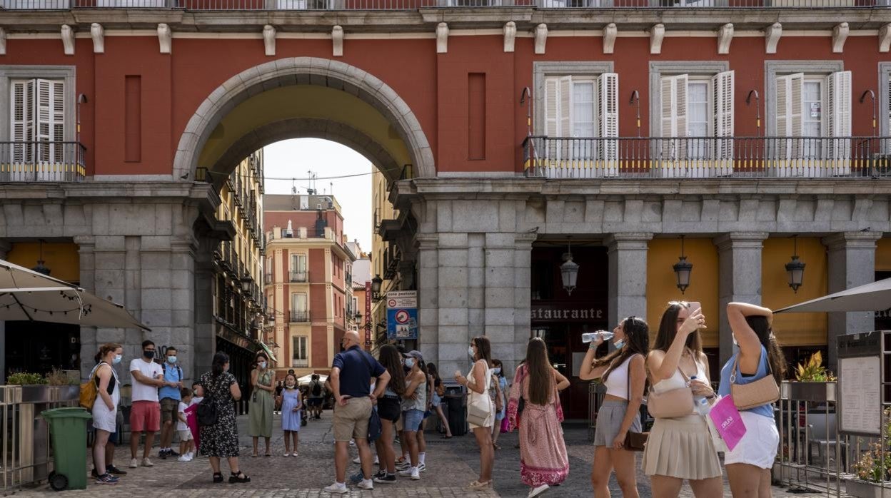 Un grupo de turistas atiende a las explicaciones de una guía, este agosto en la Plaza Mayor