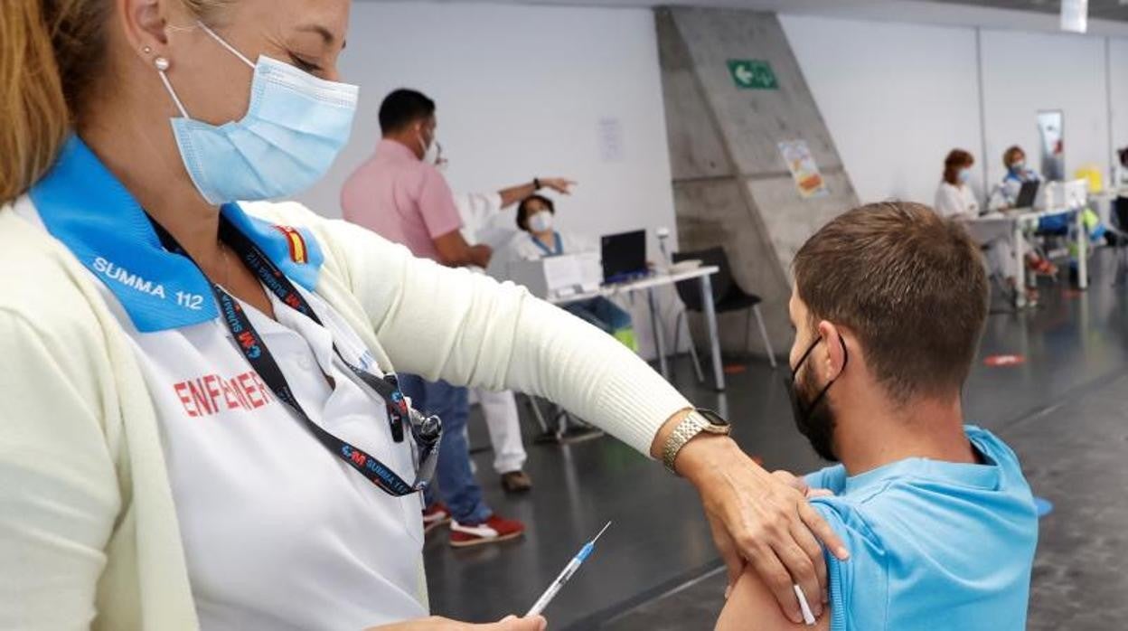 Una sanitaria de SUMMA 112 inmuniza a un usuario en el Wizink Center