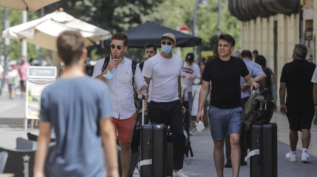 Imagen de personas paseando en Valencia con y sin mascarilla por el coronavirus